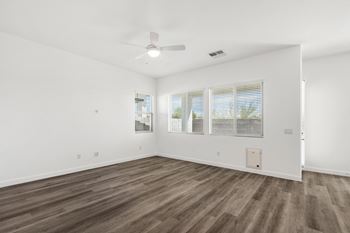a bedroom with hardwood floors and white walls